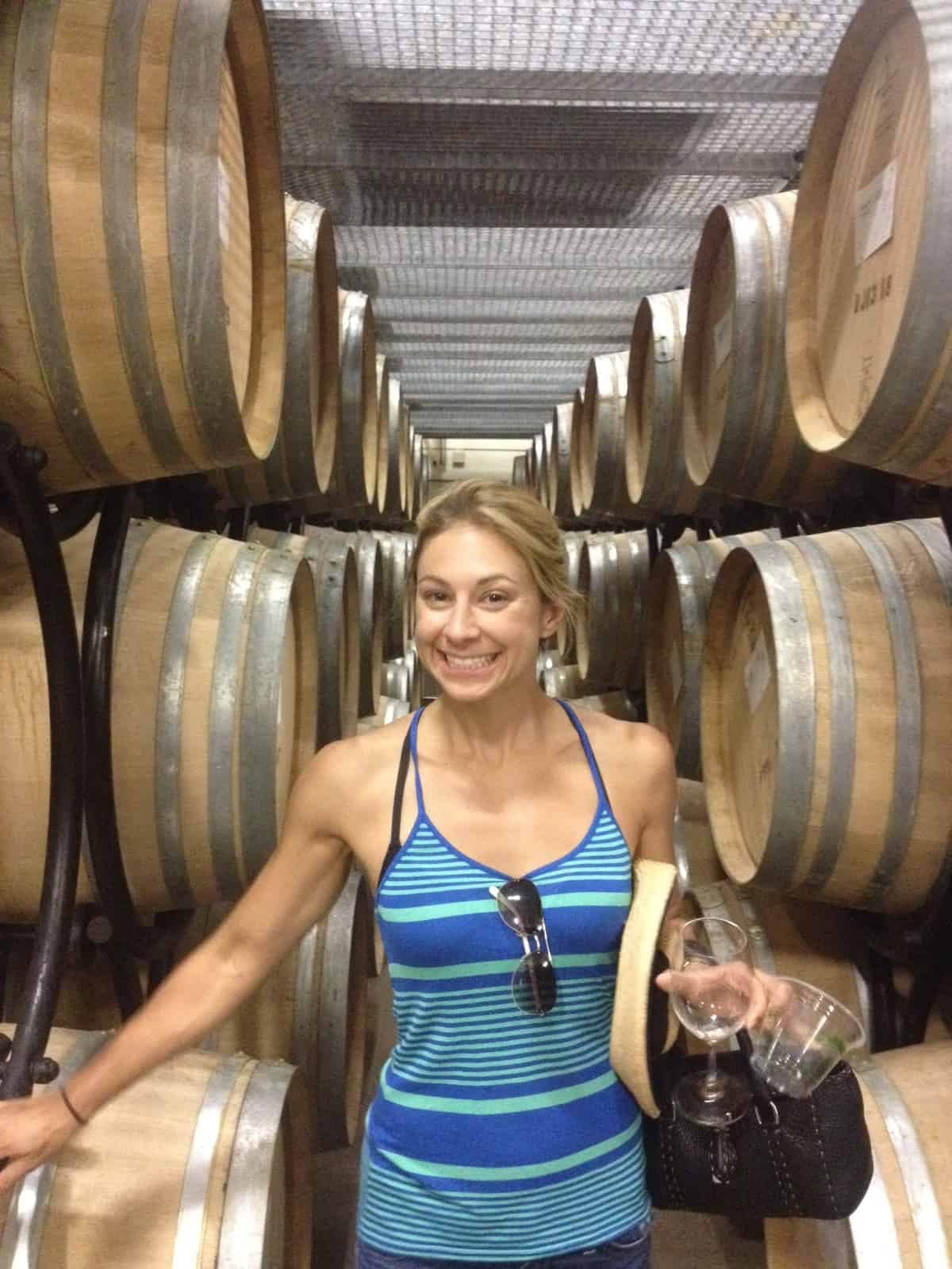 Standing in between barrels of wine in Napa Valley