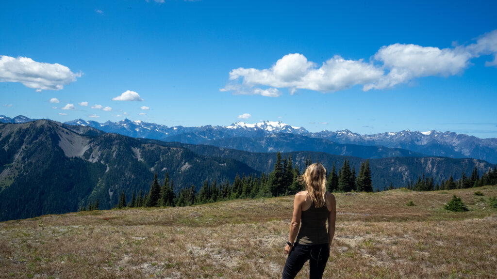 Alice Ford stands looking out at Hurricane Ridge in Olympic National Park, one of the best Pacific Northwest national parks to include on a 7-day road trip route