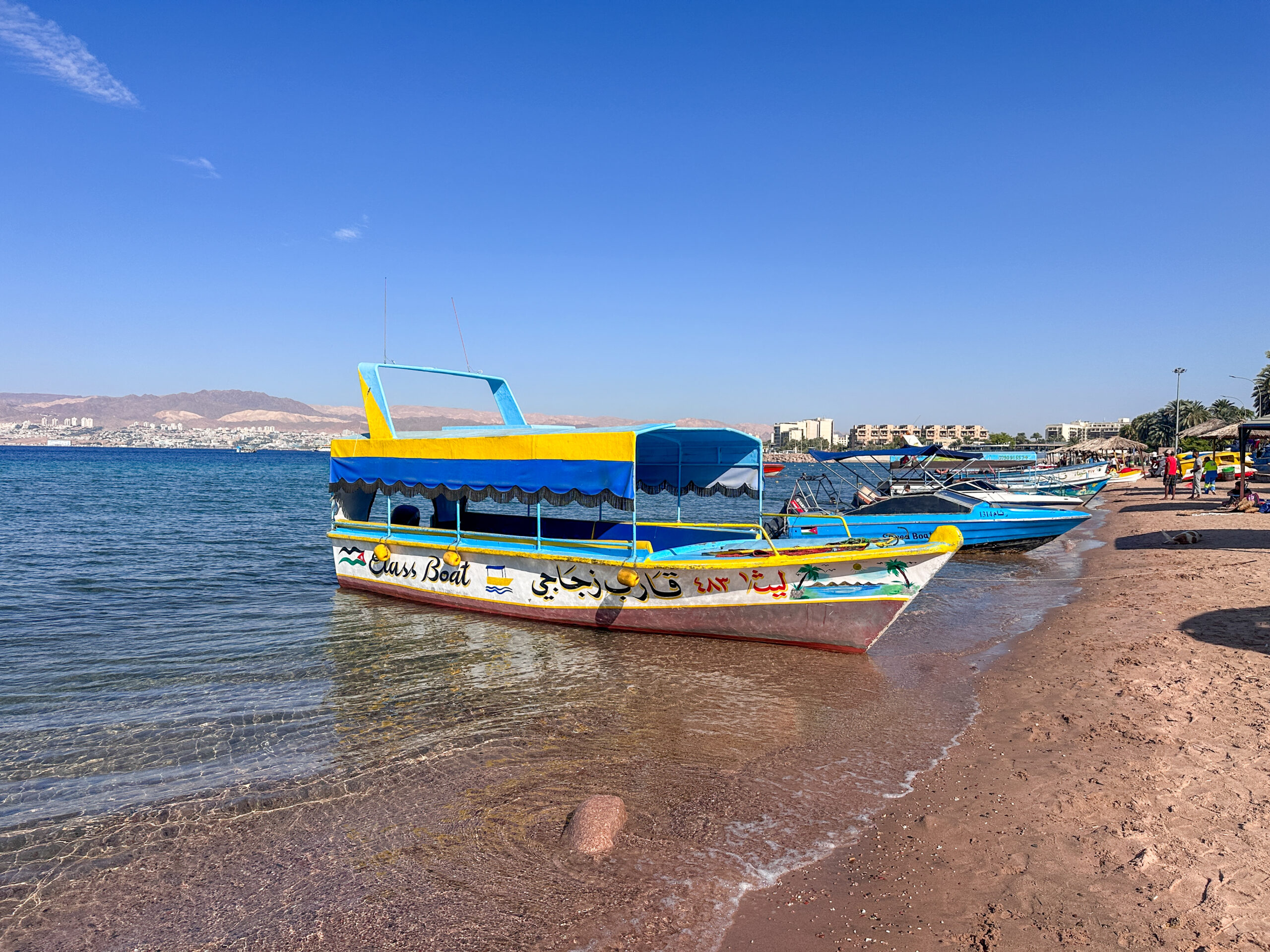 A glass bottom boat sits at the beach in Aqaba Jordan on the Red Sea 