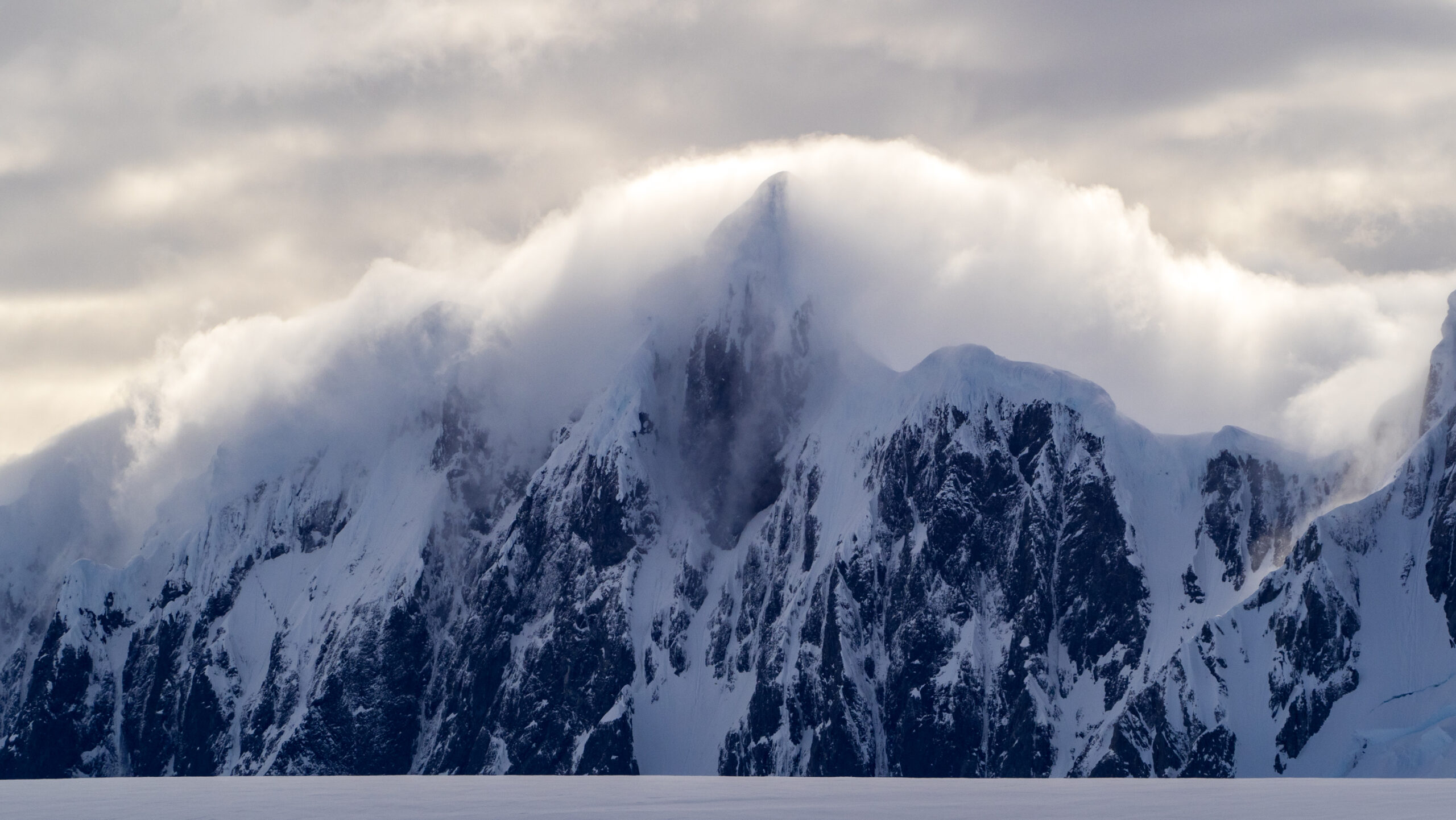 fog laden mountains with cloudy skies in antarctica 