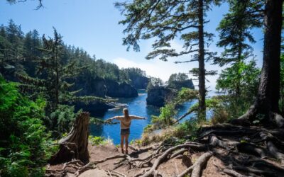 Alice Ford on a 7-day road trip through Pacific Northwest national parks, standing on cliffs overlooking Cape Flattery, the northwesternmost point in the U.S. near Olympic National Park