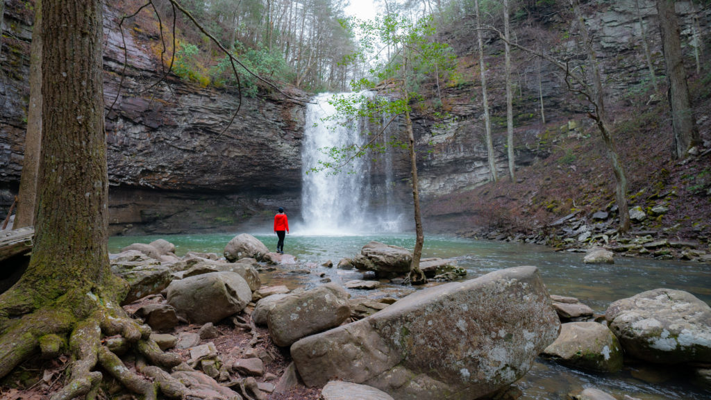 Women in red stands in front of waterfall