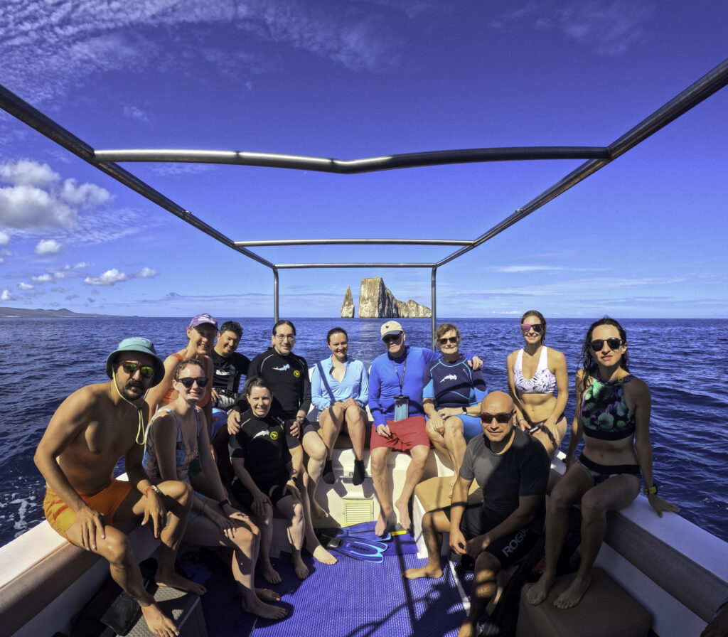 Group of people on a boat with kicker rocks in the background