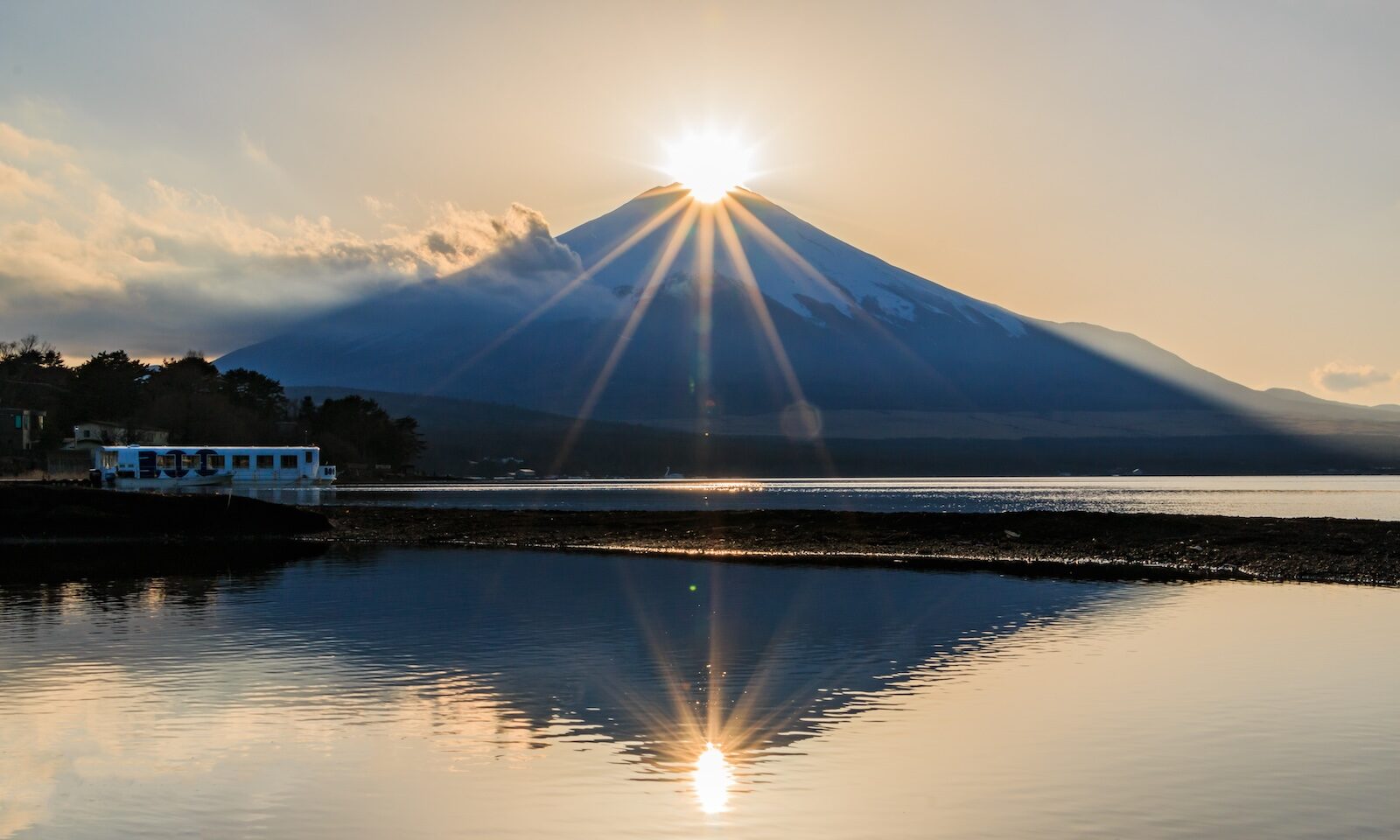 View of the rare Diamond Fuji phenomenon during my solo traveling in Japan experience with Mt. Fuji seen as the sun rises over its peak in Lake Yamanaka in Yamanashi Prefecture, Japan