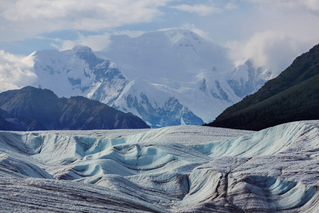 Glacier view in Wrangell-St. Elias National Park with snow-covered mountains in the background for a road trip route through 3 Alaskan national parks