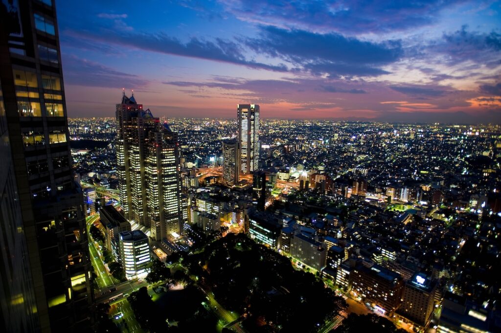 Aerial view of Tokyo's Shinjuku City at night with illuminated skyscrapers to demonstrate my arrival in the city for an 8-day solo travel trip across Japan