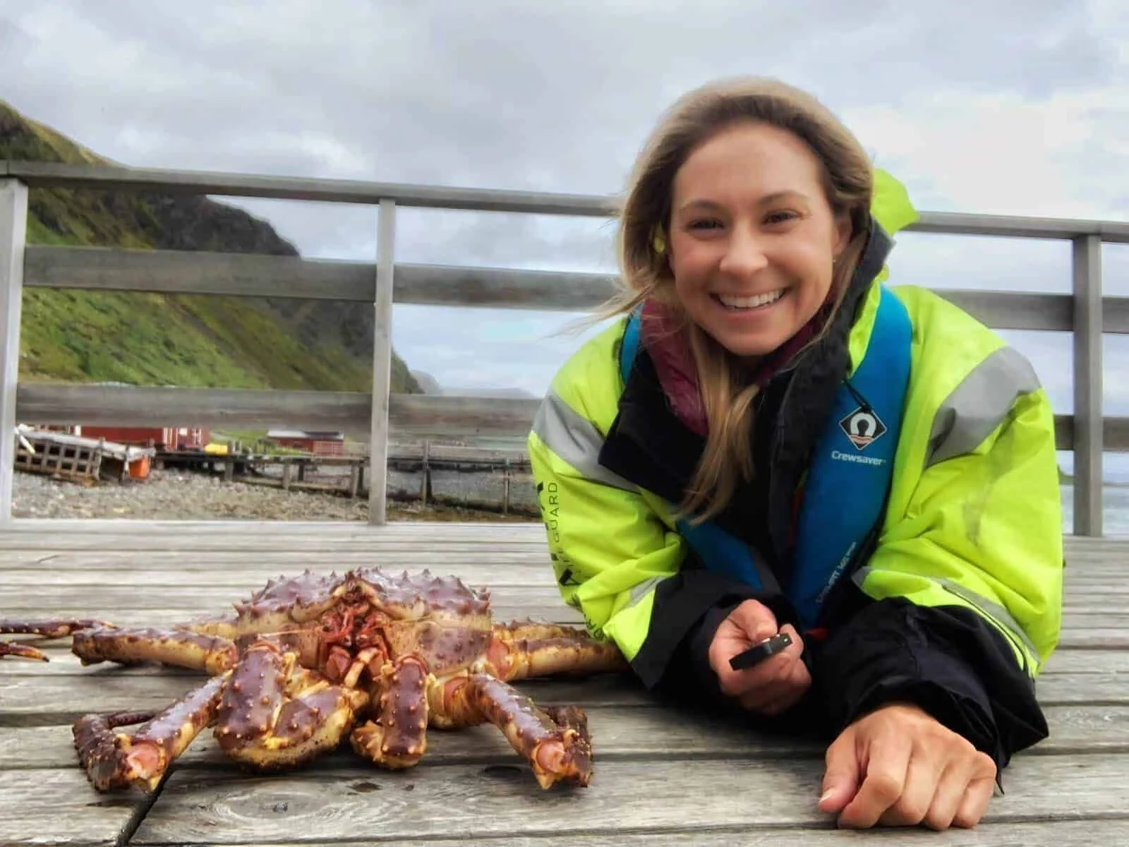 Alice Ford smiling in a high-visibility jacket on a wooden deck