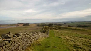 Hadrian’s Wall running across green moorland under a grey sky