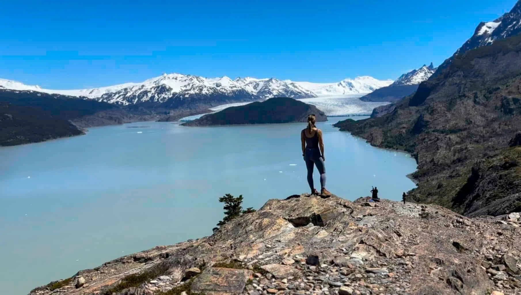 A hiker on a rock above a glacial lake in Torres del Paine, Chile